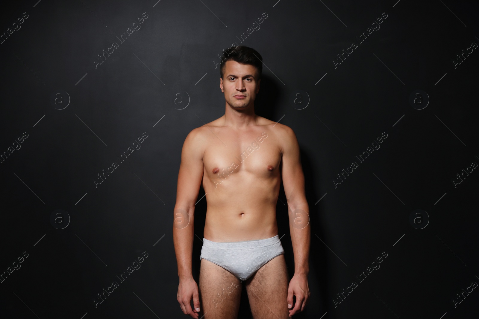 Photo of Handsome man wearing underwear on black background