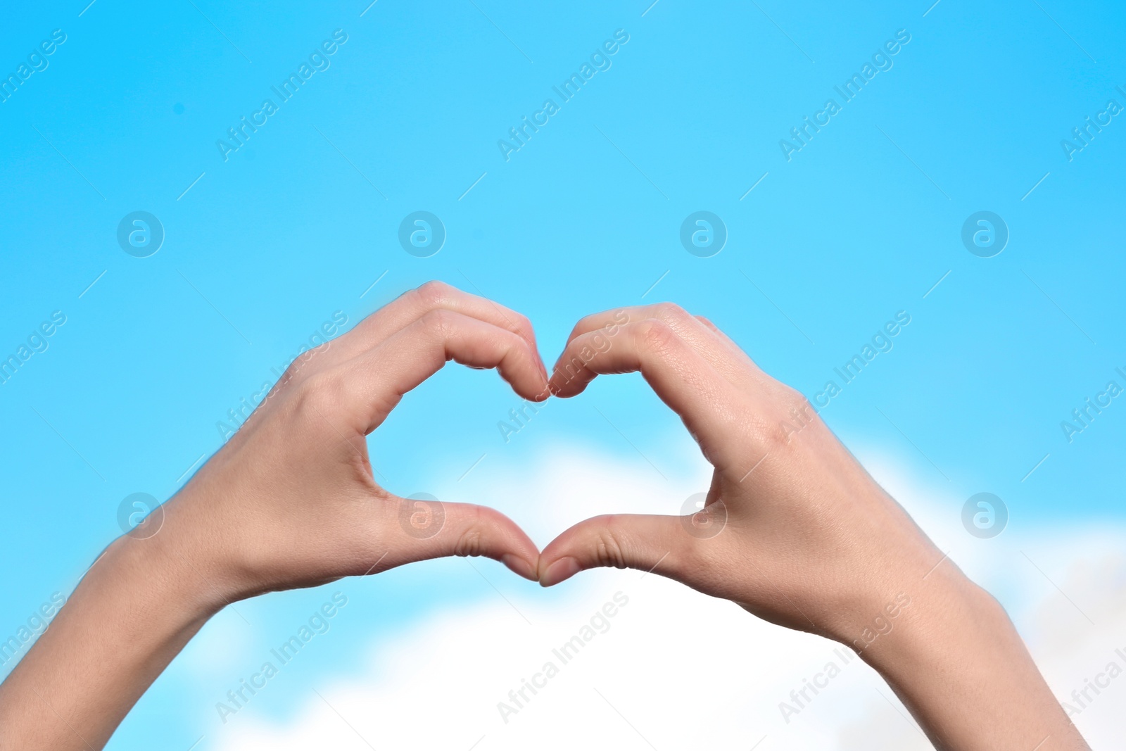 Photo of Woman making heart with her hands on color background, closeup