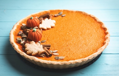 Photo of Delicious homemade pumpkin pie on light blue wooden table