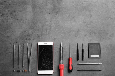 Photo of Broken mobile phone and repair tools on table, flat lay. Space for text