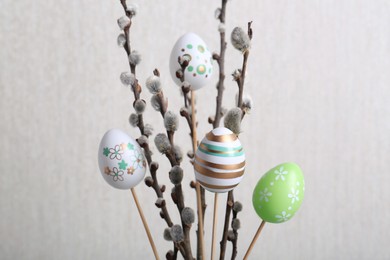 Beautiful willow branches with painted eggs on light grey background. Easter decor