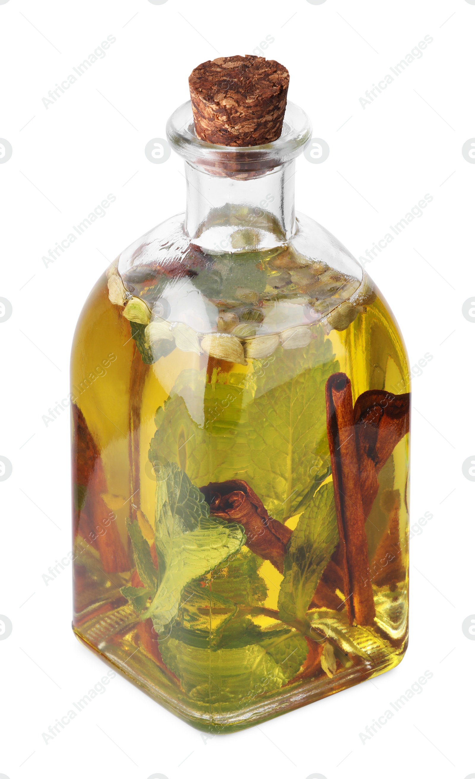 Photo of Glass bottle of cooking oil with spices and herbs isolated on white