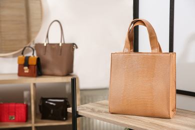 Photo of Leather woman's bag on wooden shelf in store