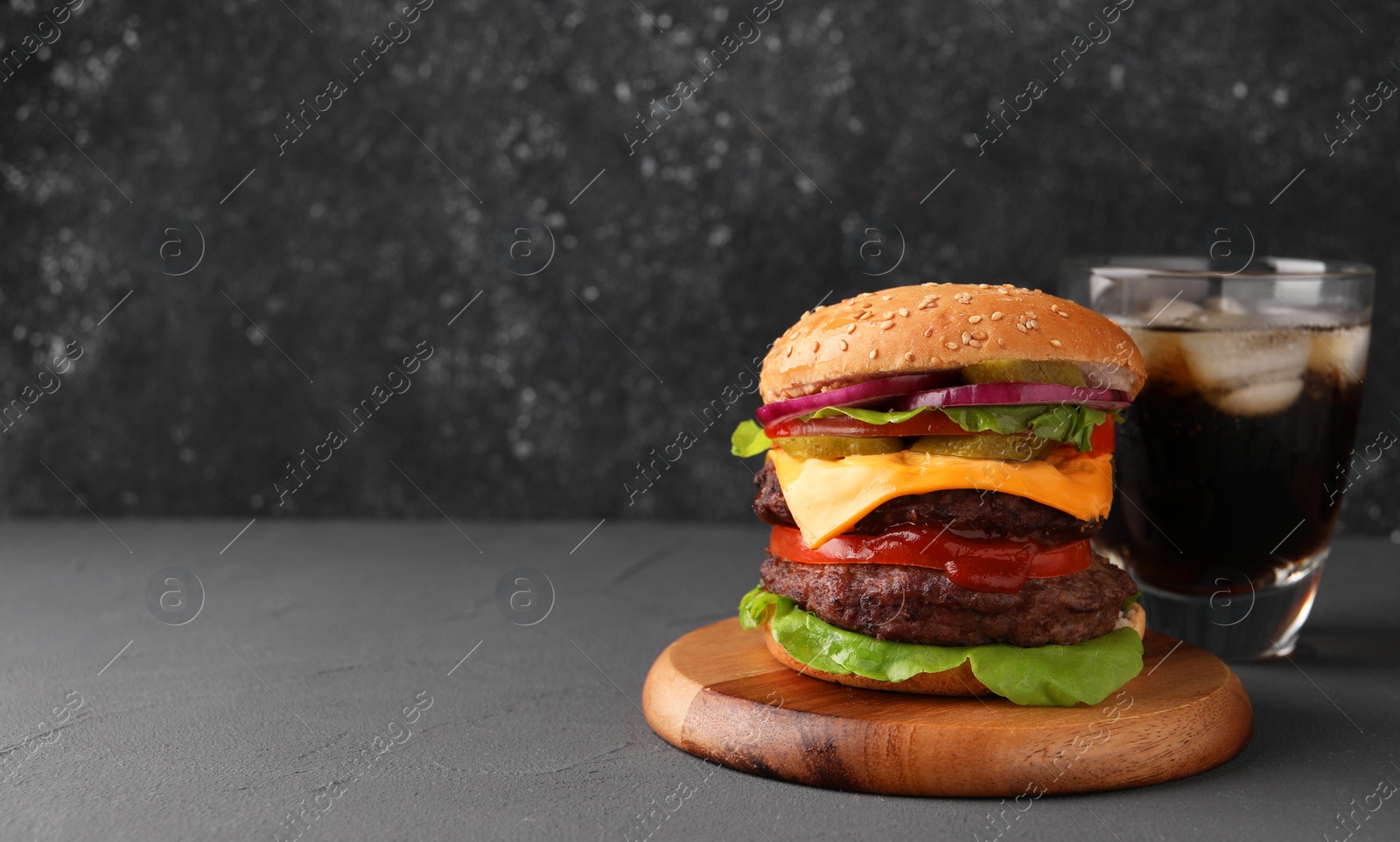 Photo of Tasty cheeseburger with patties and soda drink on grey table. Space for text