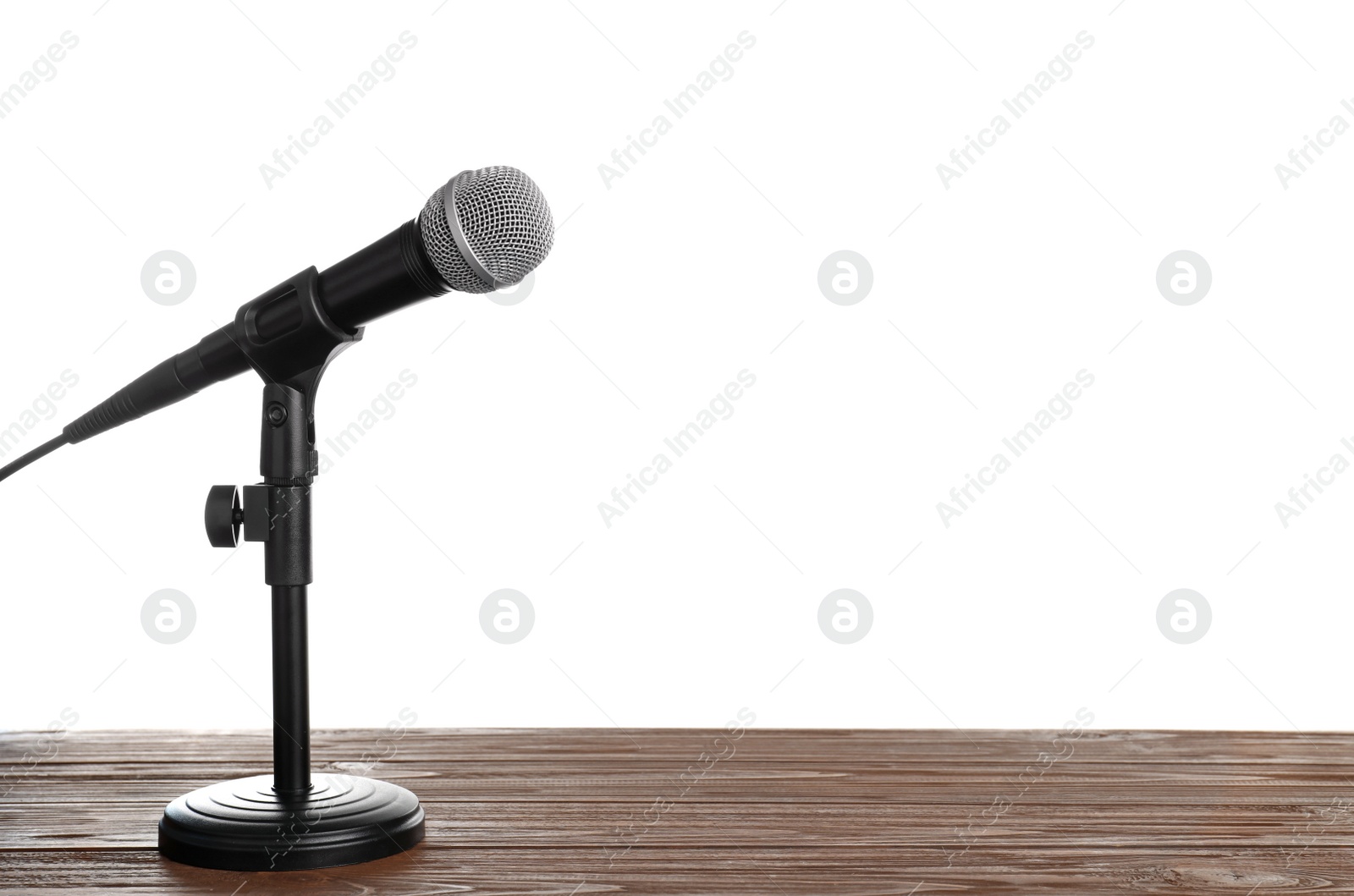 Photo of Modern microphone on table against white background. Space for text