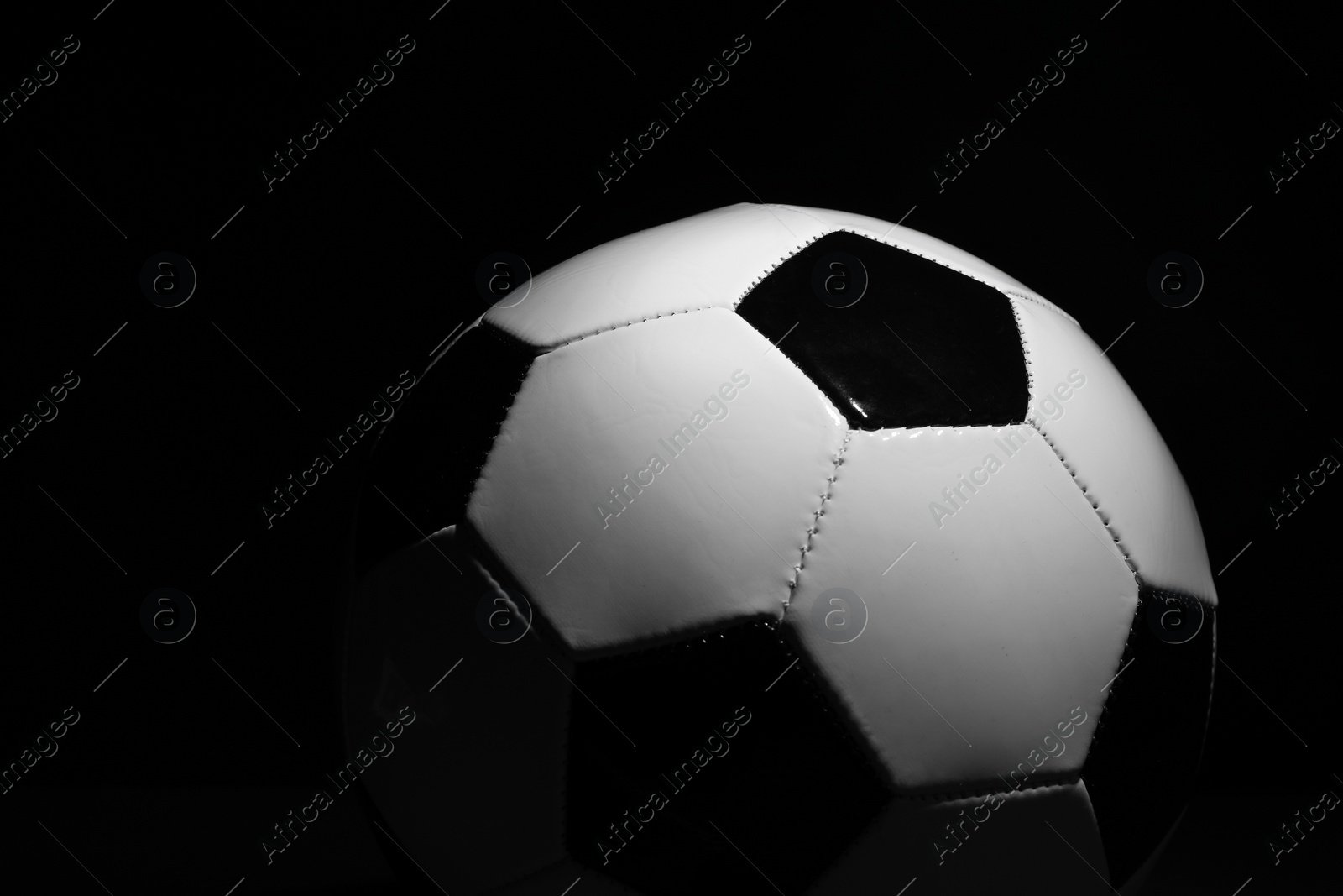 Photo of One soccer ball on black background, closeup. Sports equipment