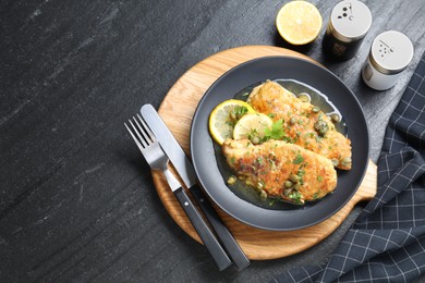 Delicious chicken piccata served on black table, flat lay. Space for text