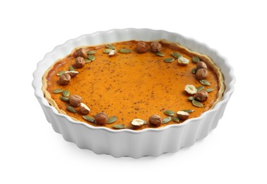 Photo of Delicious pumpkin pie with seeds and hazelnuts isolated on white