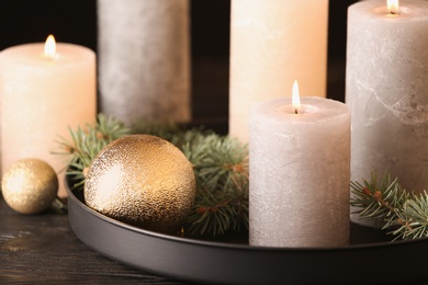 Photo of Burning candles with Christmas decoration on table, closeup