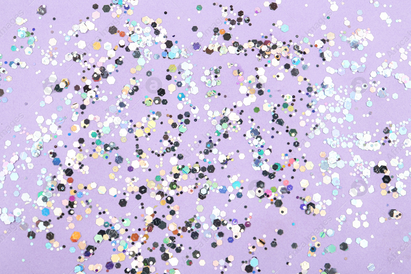 Photo of Shiny glitter on lilac background, top view