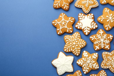 Tasty star shaped Christmas cookies with icing on blue background, flat lay. Space for text