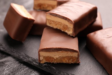 Photo of Tasty chocolate bars with nougat on gray table, closeup