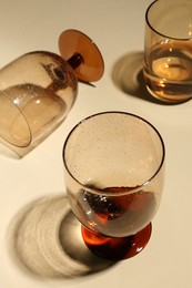 Different glasses with drinks on beige background