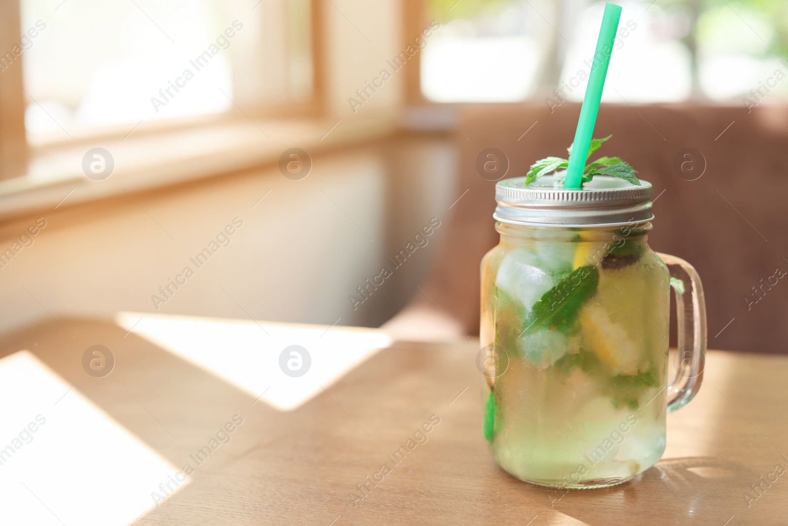 Photo of Refreshing natural lemonade with mint in mason jar on table. Detox drink