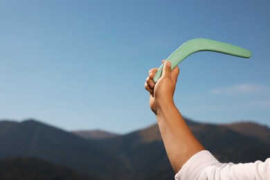 Photo of Man throwing boomerang in mountains, closeup. Space for text