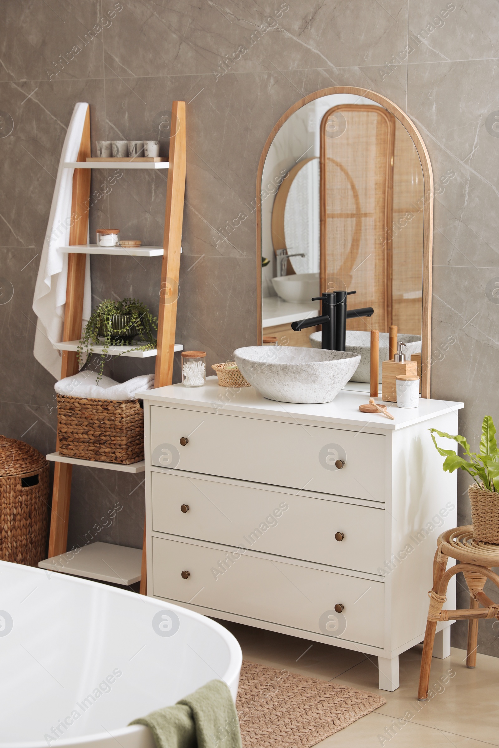 Photo of Chest of drawers with sink and beautiful green houseplants in bathroom. Interior design