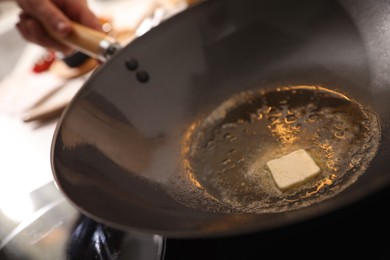 Photo of Frying pan with melted butter on stove, closeup