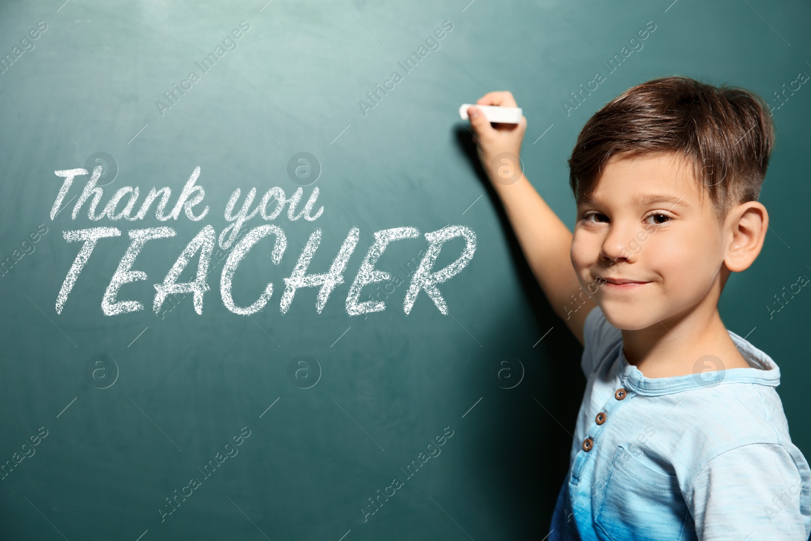 Image of Cute little boy written phrase Thank You Teacher on green chalkboard