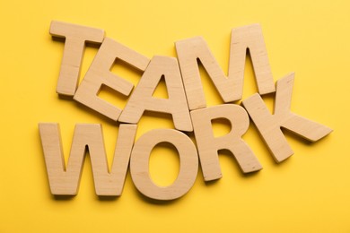 Job concept. Words Team Work made of wooden letters on yellow background, flat lay
