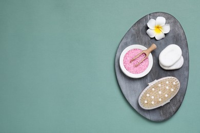 Photo of Board with spa items on pale green background, top view. Space for text