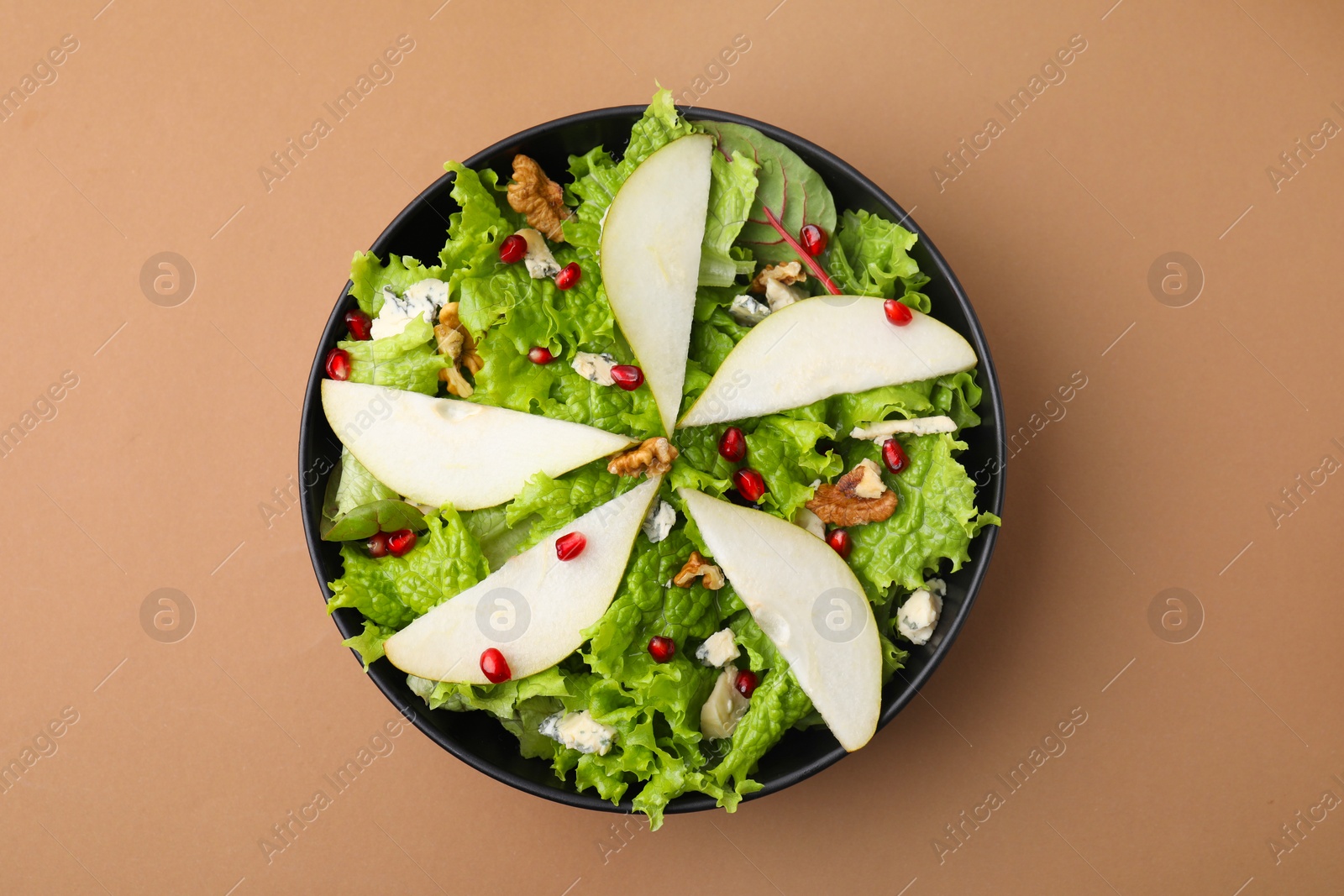 Photo of Delicious pear salad in bowl on beige background, top view