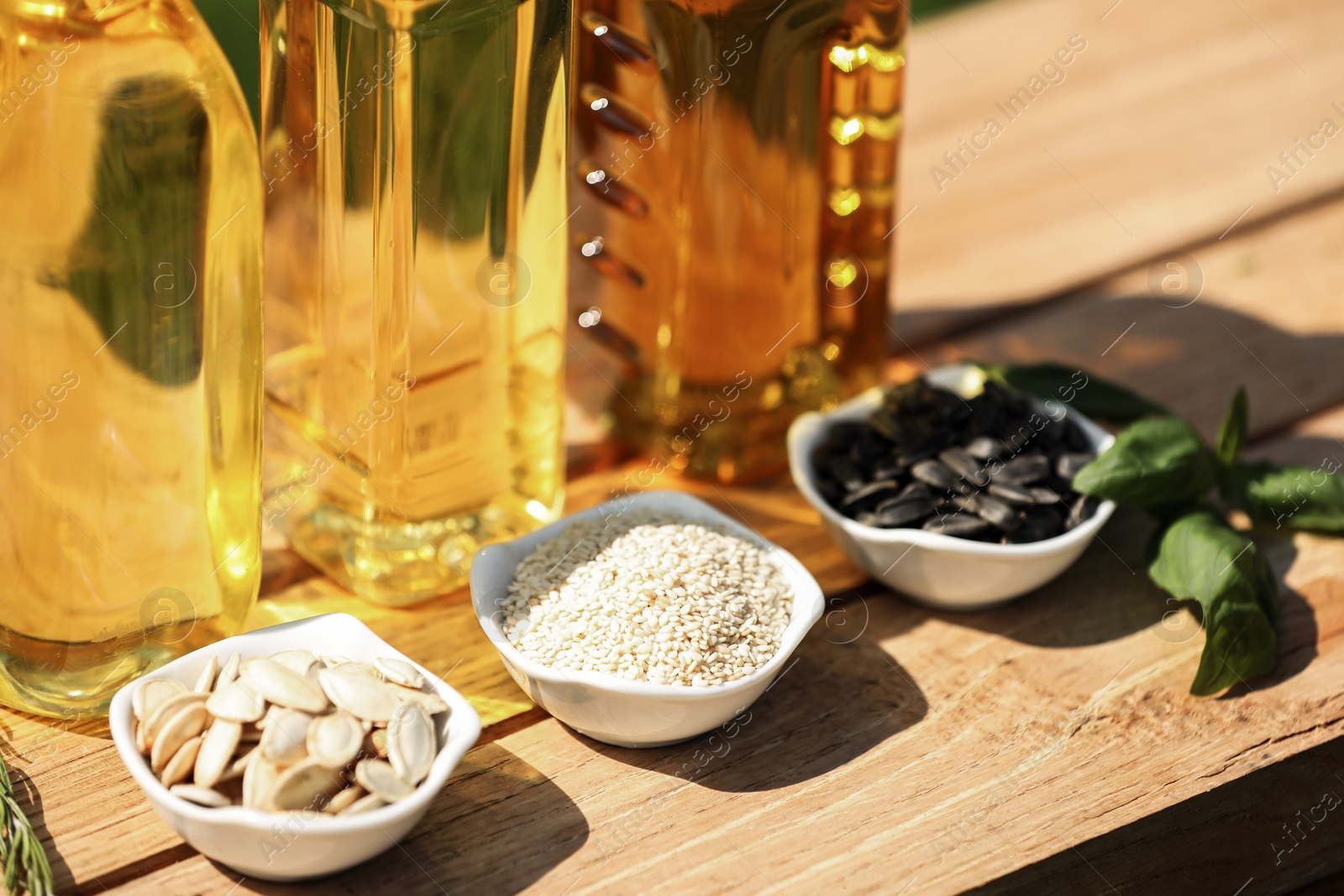 Photo of Different cooking oils and ingredients on wooden table, closeup