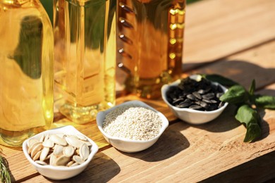 Different cooking oils and ingredients on wooden table, closeup
