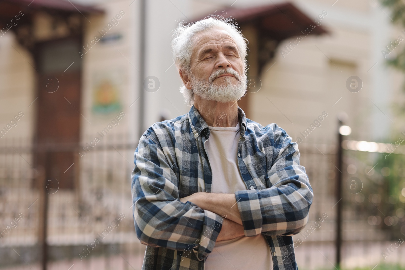 Photo of Portrait of happy grandpa with grey hair outdoors