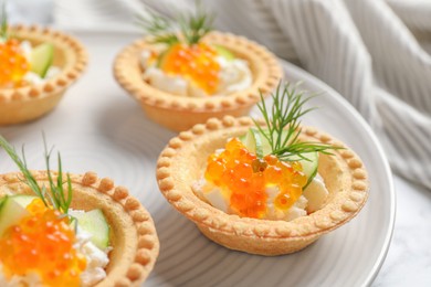 Delicious canapes with red caviar on table, closeup