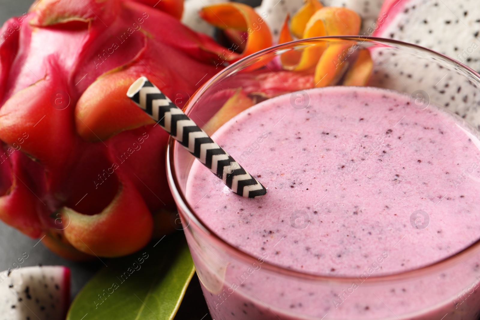 Photo of Delicious pitahaya smoothie and fresh fruits on table, closeup