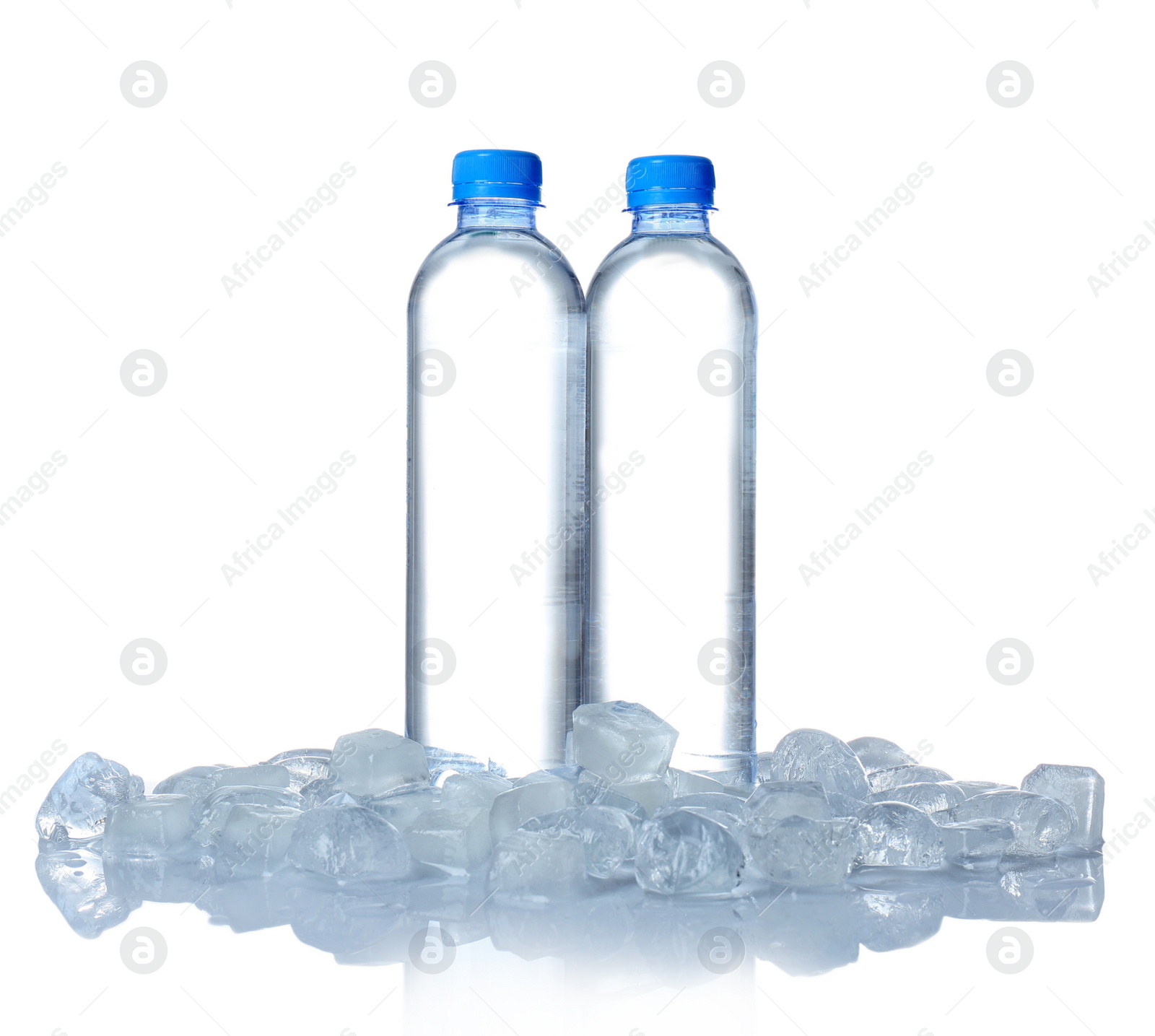 Photo of Bottles of water and ice cubes on white background