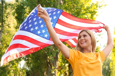 Woman with American flag in park on sunny day