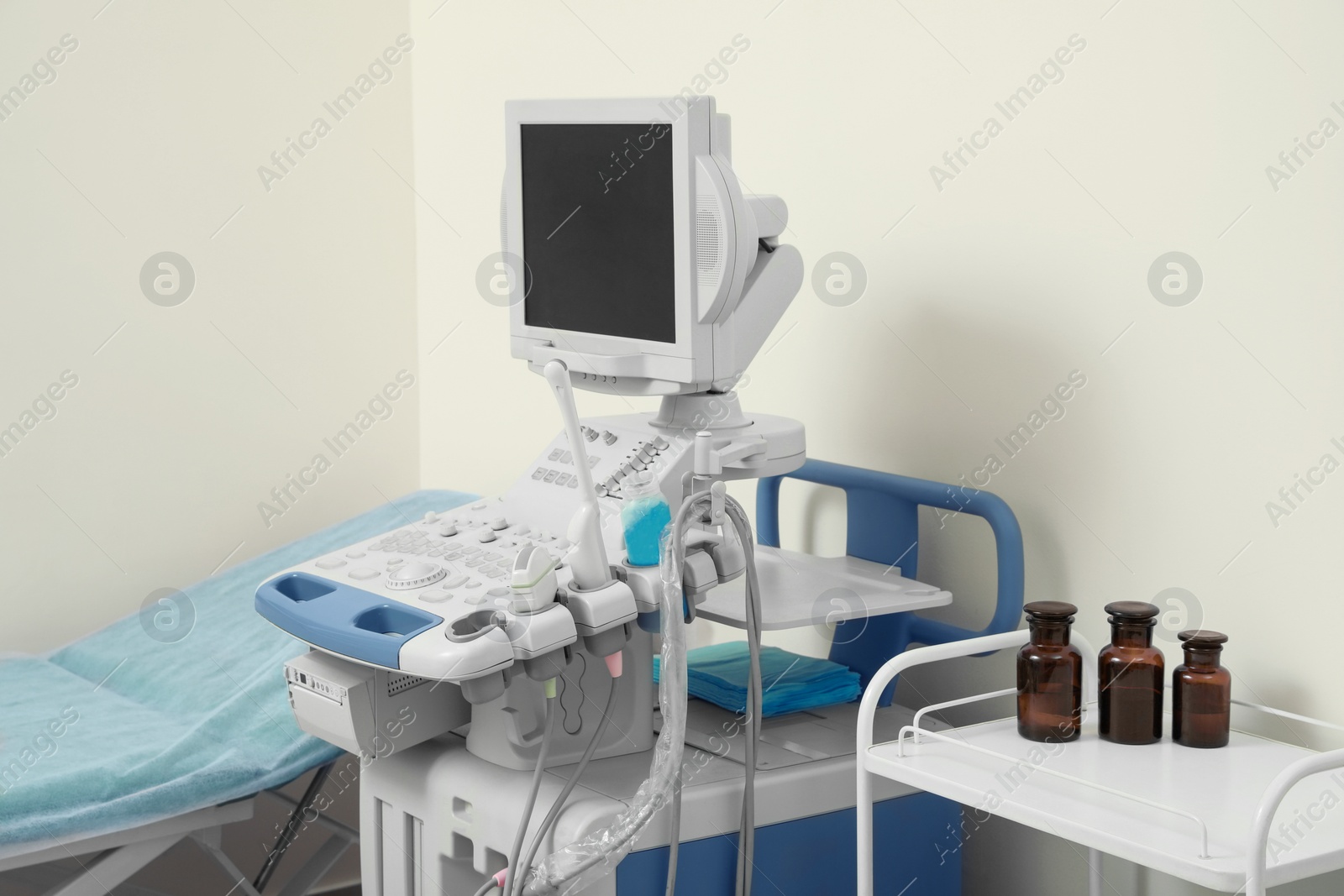 Photo of Ultrasound machine, medical trolley and examination table in hospital