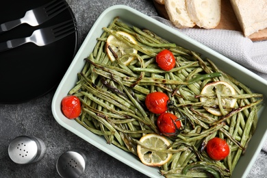 Flat lay composition with delicious baked green beans on grey table