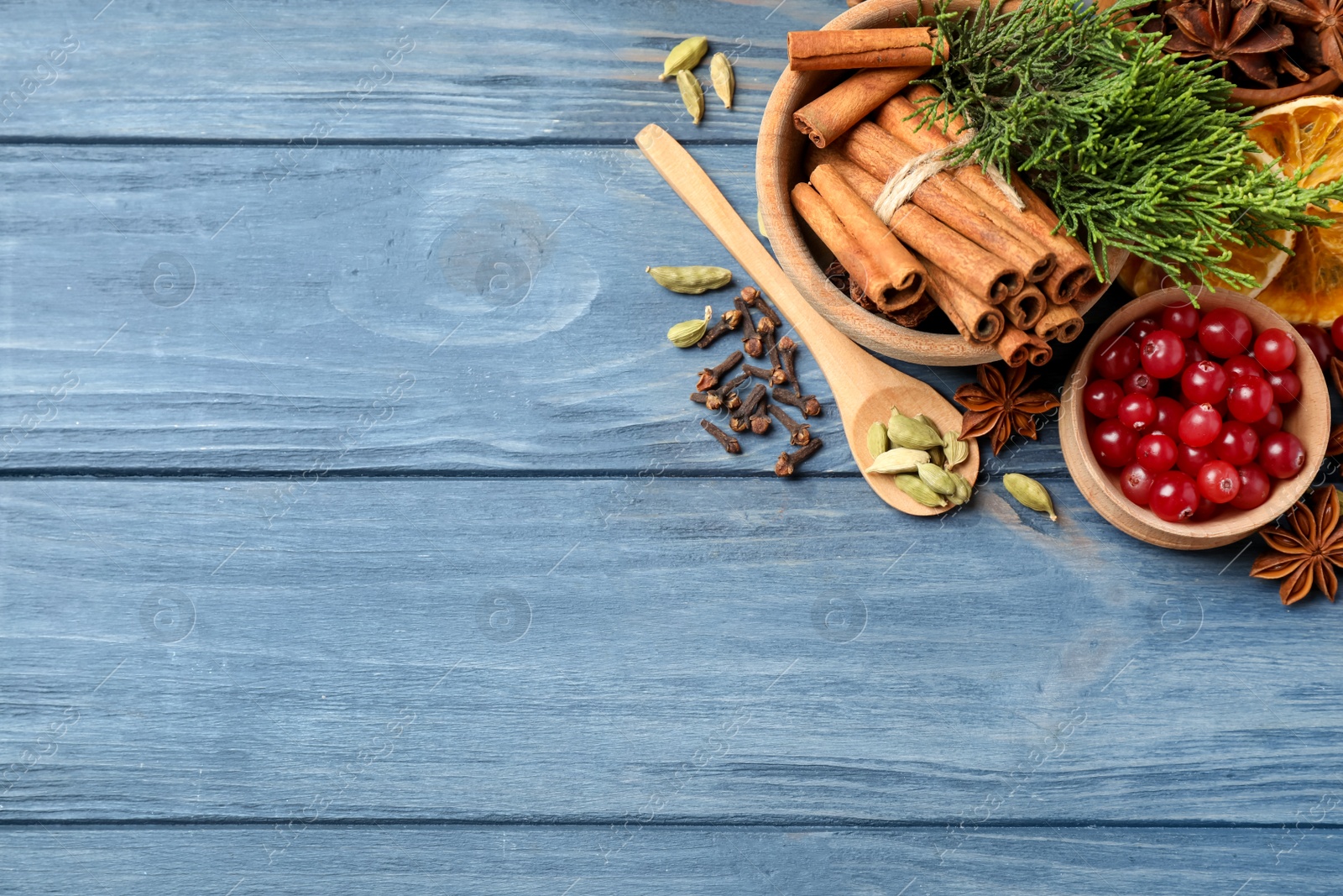 Photo of Flat lay composition with mulled wine ingredients on blue wooden table. Space for text