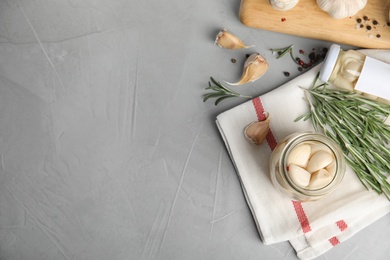 Photo of Flat lay composition with jar of pickled garlic on grey table. Space for text