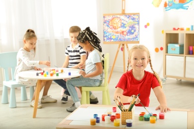 Photo of Cute little children painting at lesson indoors
