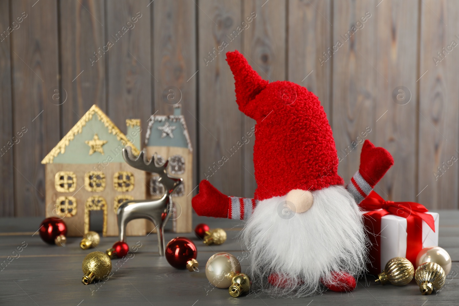 Photo of Cute Christmas gnome, gift boxes and festive decor on wooden table. Space for text