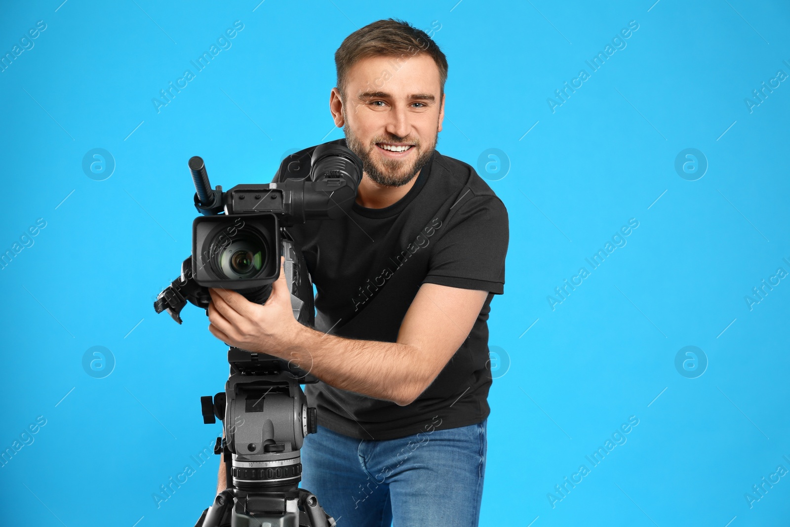 Photo of Operator with professional video camera on blue background