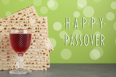 Image of Passover matzos and glass of wine on grey table. Pesach celebration