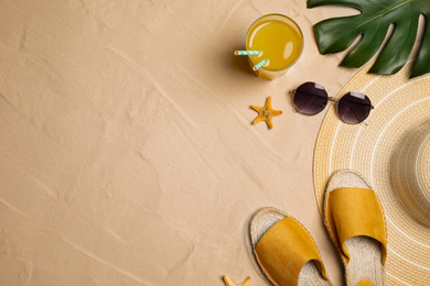 Beach accessories on sand, flat lay. Space for text