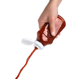 Woman pouring tasty ketchup from bottle isolated on white, closeup