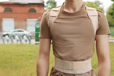 Closeup view of man with orthopedic corset outdoors