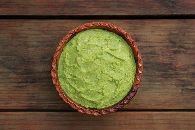 Delicious guacamole made of avocados on wooden table, top view