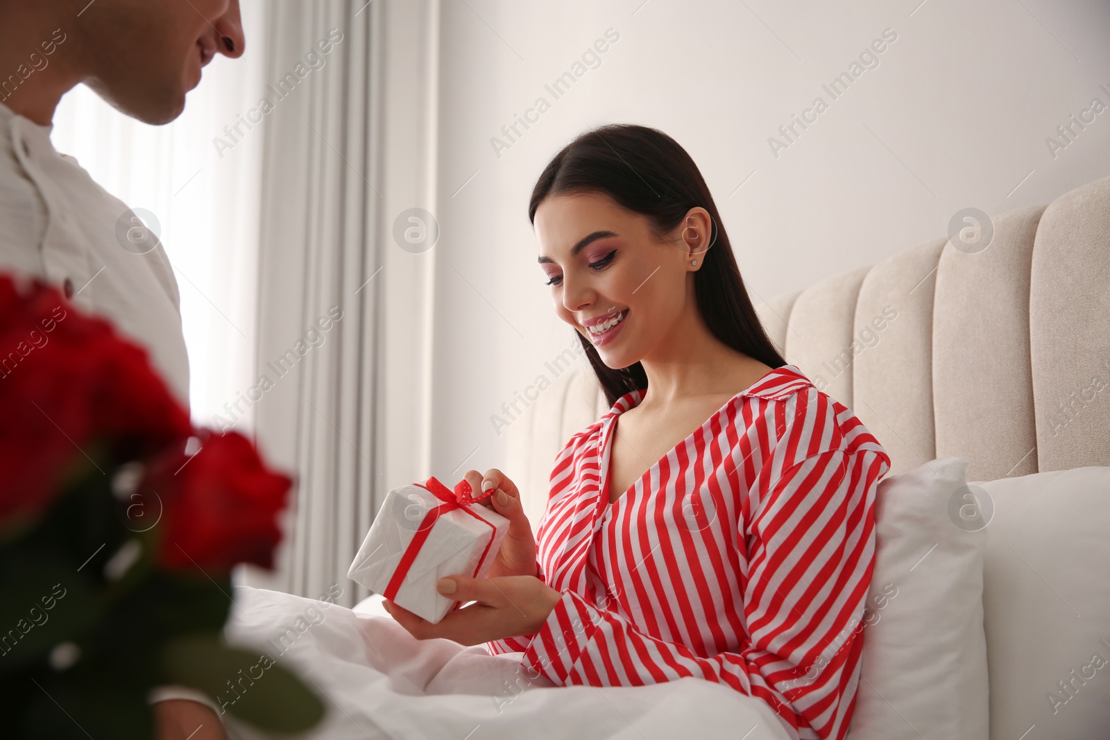 Photo of Lovely couple with gift box at home. Valentine's day celebration