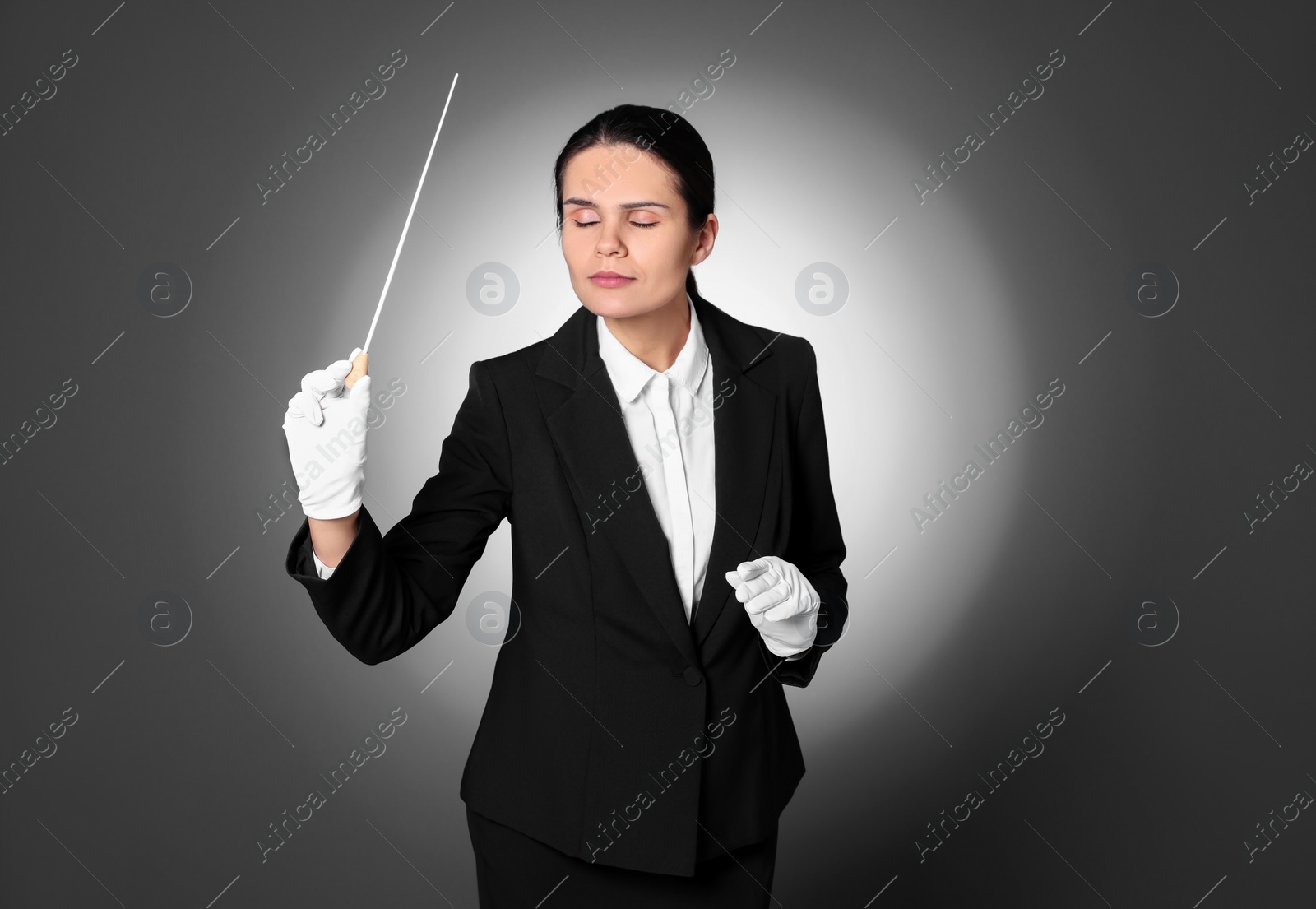 Photo of Professional conductor with baton on grey background