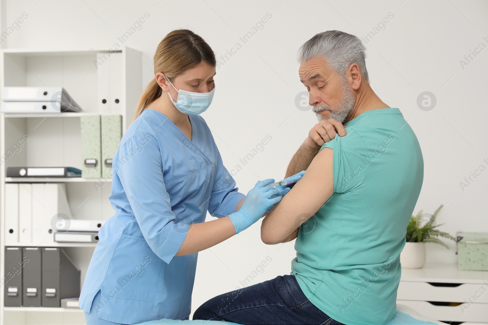 Photo of Doctor giving hepatitis vaccine to patient in clinic