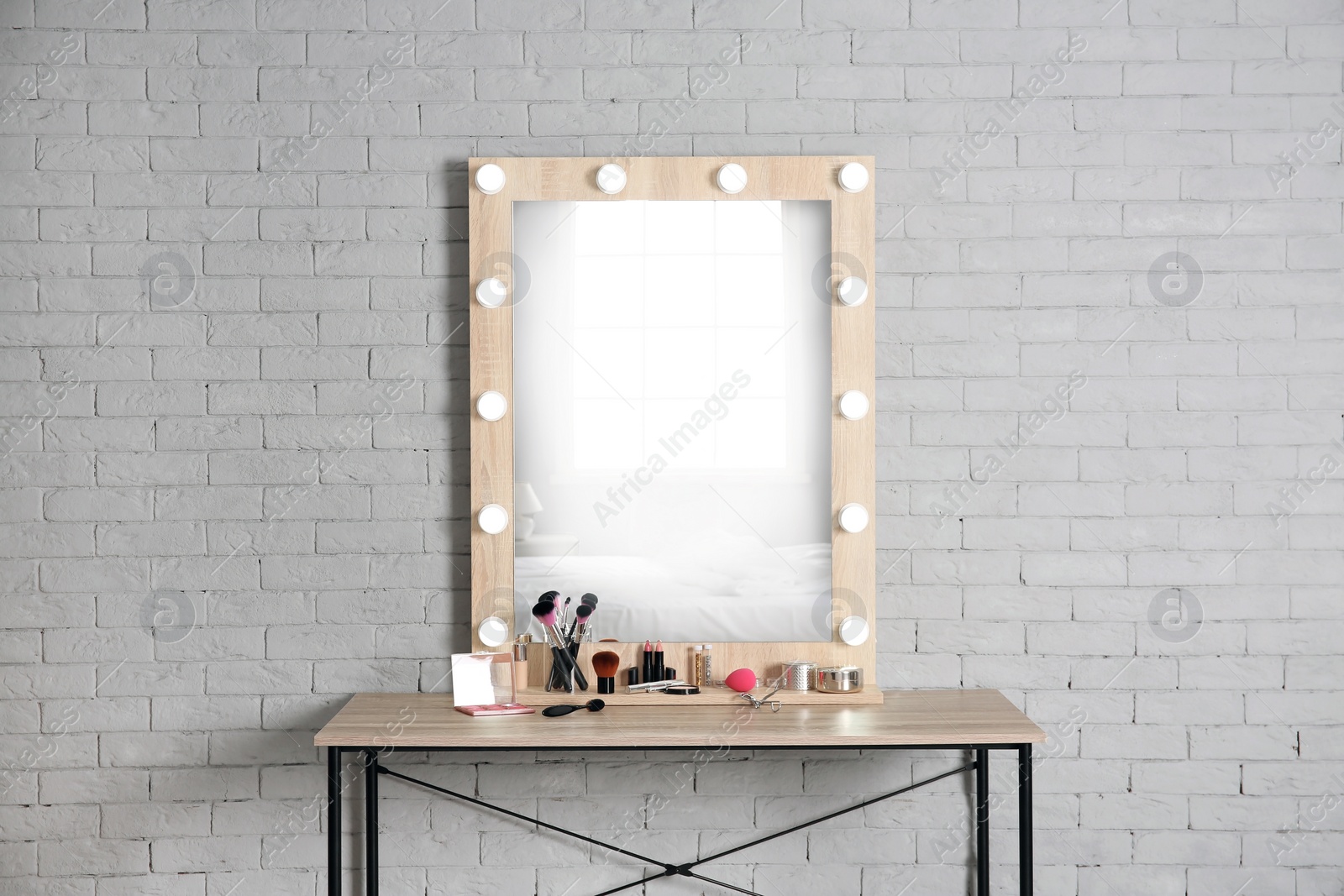 Photo of Dressing room interior with stylish mirror and set of makeup products