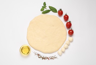 Photo of Raw dough and other ingredients for pizza on white background, top view