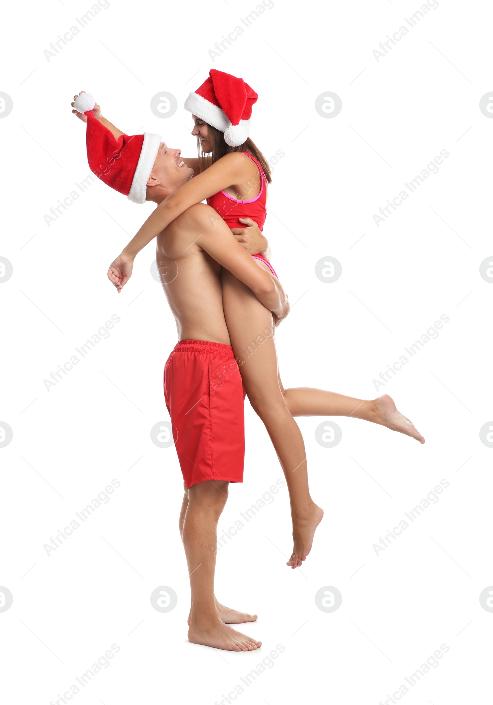 Photo of Happy couple with Santa hats together on white background. Christmas vacation